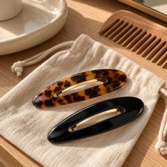 Tortoiseshell and black flat hair clips on a cotton pouch