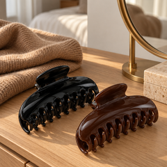 Black and espresso brown claw clips on a wooden dresser